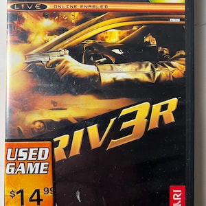 May include: Xbox game case for Driver 3. The cover features a car chase scene with a person holding a gun. The game title, "DRIVER 3", is in gold lettering. The case has a "Used Game" sticker from Hollywood Video.
