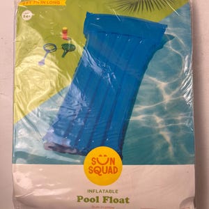 May include: A blue inflatable pool float, packaged in clear plastic. The float is 232 cm long and features a built-in pillow. The packaging includes the text "SUN SQUAD" and "Pool Float."