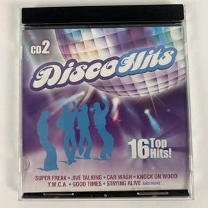 Puede incluir: Una funda de CD del álbum "Disco Hits" con un diseño morado y azul. La portada incluye una bola de discoteca, siluetas de bailarines y el texto "16 Top Hits!" con títulos de canciones como "Super Freak" y "Car Wash".