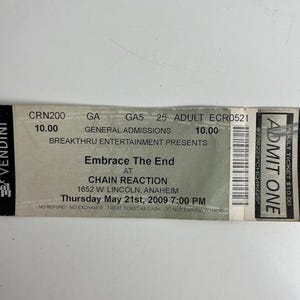 May include: A concert ticket for "Embrace The End" at Chain Reaction in Anaheim, California. The ticket is gray with black text, including the date, time, and venue address. The ticket also has a barcode and the Vendini logo.
