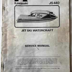 Peut inclure: Manuel de service vintage Kawasaki JS 440 Jet Ski. La couverture présente une illustration en noir et blanc d'un jet ski, le logo Kawasaki et le texte "JET SKI WATERCRAFT SERVICE MANUAL". Le manuel est imprimé aux États-Unis.