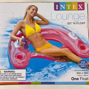 May include: An Intex Lounge Sit 'N Float pool float, with a woman in a yellow bikini. The float is pink and has a built-in drink holder. The box reads "For Adults Only" and the approximate deflated size is 60in x 39in.