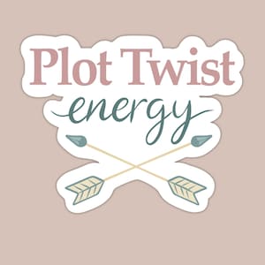 May include: A sticker with the words "Plot Twist energy" in pink and teal script. Two crossed arrows with teal tips and cream-colored shafts are below the text. The sticker has a white border and is on a light brown background.