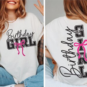 May include: Cream-colored t-shirt with the text "Birthday GIRL" in black and pink. The front of the shirt features the text in a script font with a pink bow. The back of the shirt has the text vertically with a pink bow.
