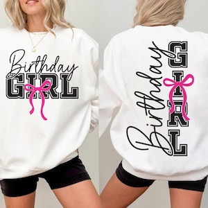 May include: White sweatshirt with the text "Birthday GIRL" in black script and block letters, accented with a pink bow. The design is on the front and back of the sweatshirt. The sweatshirt is worn by a person.