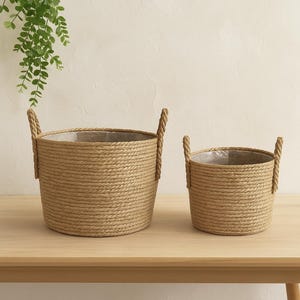 Peut inclure: Deux paniers en jute tressé avec des poignées en corde. Le plus grand mesure environ 30 cm de diamètre et 25 cm de hauteur, tandis que le plus petit mesure environ 20 cm de diamètre et 18 cm de hauteur. Les deux ont une doublure en plastique transparent.