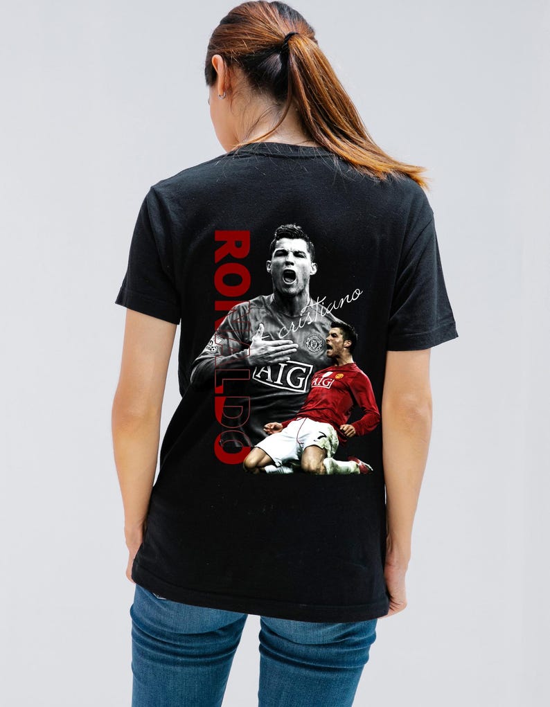 Pu&ograve; includere: T-shirt nera con grafica di un calciatore in maglia rossa e bianca. La parola "RONALDO" &egrave; stampata verticalmente in rosso, con il nome "cristiano" in corsivo.