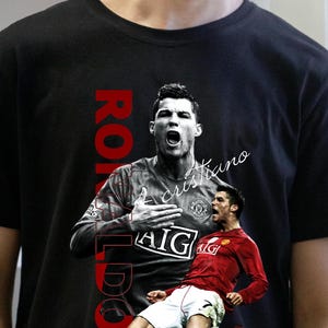 Pu&ograve; includere: T-shirt nera con grafica di Cristiano Ronaldo in divisa da calcio. La parola "RONALDO" &egrave; stampata verticalmente in rosso sul lato sinistro. Il nome "cristiano" &egrave; scritto in corsivo. La maglietta ha un girocollo.
