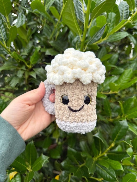 A fully crocheted amigurumi beer mug — soft, squeezable, and absurdly charming as desk decor or a gag gift you'd actually keep.