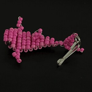 Pu&ograve; includere: Un portachiavi rosa a perline a forma di pesce. Il pesce &egrave; fatto di piccole perline rosa rotonde infilate con filo d'argento. Un fermaglio color argento &egrave; attaccato alla coda del pesce.
