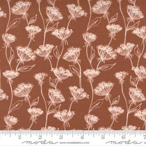 May include: A fabric with a repeating pattern of white floral line drawings on a brown background. The flowers have a delicate, airy appearance, with thin stems and detailed blooms. The fabric is suitable for quilting and other craft projects.