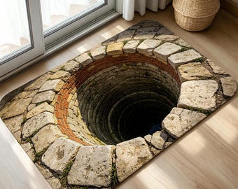 May include: A rectangular floor mat featuring a high-contrast 3D optical illusion print of a deep, dark stone well. The design displays a circular opening surrounded by weathered gray stone blocks and a ring of red bricks, creating a realistic depth effect.