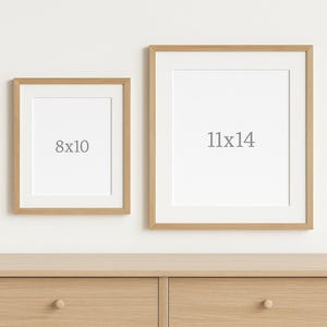 Op de afbeelding: Twee ingelijste kunstdrukken, &eacute;&eacute;n van 20x25 cm en de andere van 28x35 cm, worden gepresenteerd op een lichte houten dressoir. De lijsten zijn licht van kleur en de prints hebben een witte passe-partout. De tekst "8x10" en "11x14" staat op de kunst.