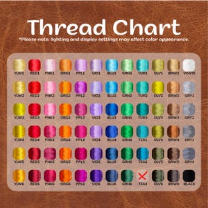 May include: A thread chart with a variety of colors, including red, pink, orange, purple, blue, green, and brown. The text "Thread Chart" is at the top, with a note about lighting affecting color appearance. The chart is on a brown background.