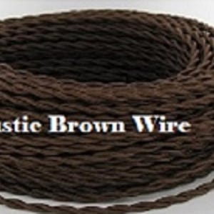 May include: Three spools of decorative wire in black, rustic brown, and grey-steel colours. The black wire spool has the text "Black Wire". The rustic brown wire spool has the text "Rustic Brown Wire". The grey-steel wire spool has the text "GRAY/STEEL WIRE".