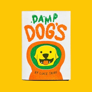 May include: A white rectangular card with the words ".DAMP DOG'S" in orange and green lettering. Below the text is a yellow dog illustration with an orange and green outline. The text "BY LUKE TRIBE" is at the bottom.