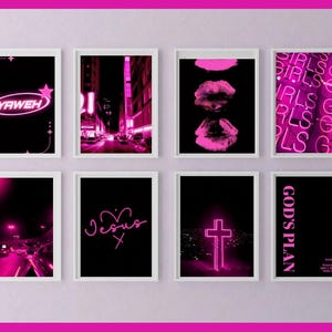 May include: A collection of eight framed art prints with a black background and neon pink designs. The prints feature text like "YAWEH", "Jesus", and "GOD'S PLAN", along with images of lips, a cross, and cityscapes. The overall theme is modern and spiritual.