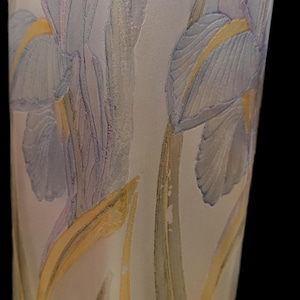 May include: A frosted glass vase with a floral design. The vase features blue and purple iris flowers with yellow accents and green leaves. The vase is approximately 8 inches tall.
