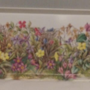 May include: Rectangular white serving tray with a floral design. The tray features a colorful illustration of wildflowers in shades of yellow, pink, purple, and blue. The flowers are set against a backdrop of green foliage and brown grasses.