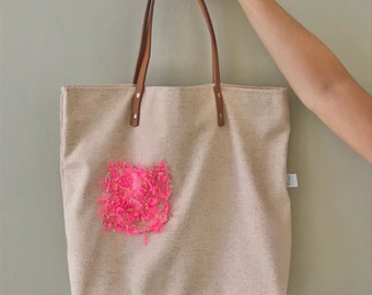 Tote handbag with decorative pocket.