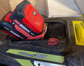 Könnte beinhalten: Zwei rote und schwarze Ozito X Power Exchange 4.0Ah Akkus sind in ein schwarz-gelbes Elektrowerkzeug eingesetzt. Das Werkzeug trägt die Aufschrift "Lithium +36V" und "Brushless".
