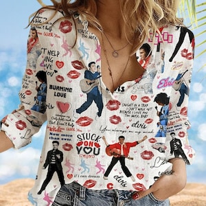May include: White button-down shirt featuring Elvis Presley imagery, including illustrations of Elvis with a guitar, hearts, and lipstick prints. The shirt has long sleeves and a V-neck design, with text elements like "Burning Love" and "Stuck on You."