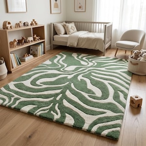 Peut inclure: Un tapis rectangulaire à poils longs présentant un motif ondulé organique répétitif en vert sauge et blanc crème. Le design se compose de lignes fluides et interconnectées qui créent une esthétique abstraite sur toute la surface.
