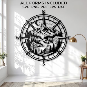 May include: A black circular metal wall art piece featuring a compass design with a mountain range, a winding river, a forest, and a small cabin. The text ALL FORMS INCLUDED SVG PNG PDF EPS DXF is displayed at the top of the wall art design.