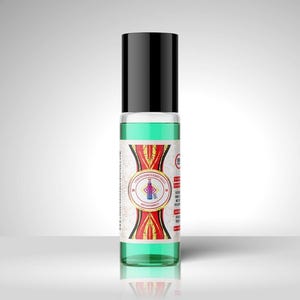 Puede incluir: Un frasco roll-on de vidrio transparente con tapa negra, lleno de líquido verde claro. El frasco tiene una etiqueta con un diseño rojo, dorado y blanco y texto. El producto es una fragancia o aceite corporal.