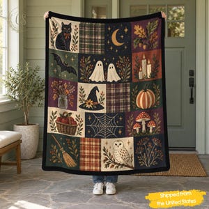 Op de afbeelding: Een rechthoekige plaid met een patchworkontwerp met diverse herfst- en Halloween-motieven, waaronder een zwarte kat, spoken, een pompoen, een heksenhoed, een spinnenweb, een uil, kaarsen, een bezem en ruitpatronen in donkere tinten.