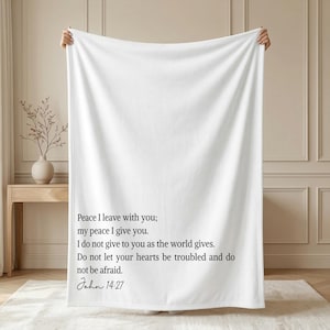 Könnte beinhalten: Eine weiße Decke mit dem Text "Peace I leave with you; my peace I give you. I do not give to you as the world gives. Do not let your hearts be troubled and do not be afraid. John 14:27" in Schwarz.