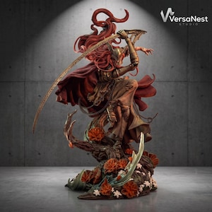 May include: A detailed fantasy figurine featuring a warrior with long flowing red hair, wearing golden armor and a dark red cape, wielding a large curved blade. The figure stands atop a base decorated with orange flowers and white blossoms.
