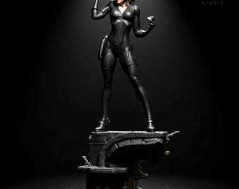 May include: A black Catwoman figurine in a dynamic pose, wearing a form-fitting suit, a cowl, and heels. The figure stands on a detailed, dark-colored base. The VersaNest Studio logo is visible in the background.