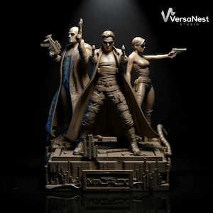 May include: A detailed sculpture featuring characters from The Matrix. The figures, including Neo, Trinity, and Morpheus, are depicted in action poses, holding guns. The base of the sculpture has the word "MATRIX" inscribed. The overall color is a muted brown.