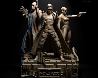 Puede incluir: Una escultura detallada con personajes de The Matrix. Las figuras, incluyendo Neo, Trinity y Morpheus, se representan en poses de acción, sosteniendo armas. La base de la escultura tiene la palabra "MATRIX" inscrita. El color general es un marrón apagado.
