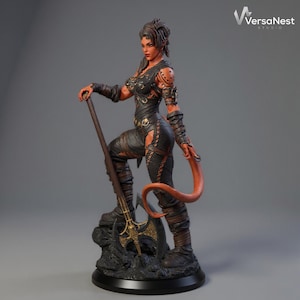 Puede incluir: Figura detallada de una guerrera con piel roja, vestida con armadura de cuero negro y sosteniendo un arma de asta. La figura tiene una larga cola naranja y est&aacute; posada sobre una base rocosa. El logotipo de VersaNest Studio es visible.
