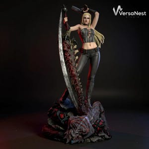 May include: A detailed statue of a female warrior with long blonde hair, wearing a black corset, pants, and holding a large scythe and two pistols. The statue is on a detailed base with a dark background.