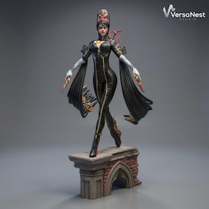 May include: A detailed figurine of a character in a black bodysuit with gold accents, long black sleeves, and a distinctive hairstyle. The figure is posed on a brick and stone platform, holding two guns. The VersaNest Studio logo is visible.