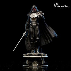 Puede incluir: Una figura negra y plateada de un personaje con una capa con capucha, sosteniendo un sable de luz. La figura tiene una máscara teñida de rojo y está de pie sobre una base detallada. El logotipo de VersaNest Studio está en la esquina superior derecha.