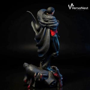 May include: A detailed statue of a figure in a black cloak with a fur collar, red accents, and a dark base with clawed hands. The statue is from VersaNest Studio.