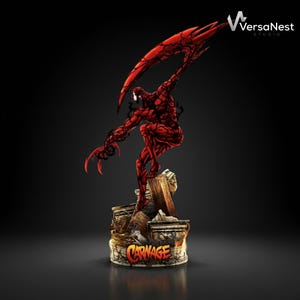 Puede incluir: Estatua de Carnage roja y negra. La figura está posada dinámicamente, con garras afiladas y un gran apéndice en forma de ala. La base presenta la palabra "CARNAGE" en una fuente estilizada. El logotipo de VersaNest Studio está en la esquina superior derecha.