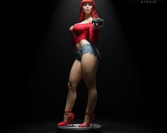 Peut inclure: Statue d'une femme aux cheveux roux, vêtue d'un haut rouge, d'un short en jean et de talons hauts rouges, tenant un appareil photo. La statue est sur un socle noir sur fond sombre. Le logo VersaNest Studio est en haut à droite.