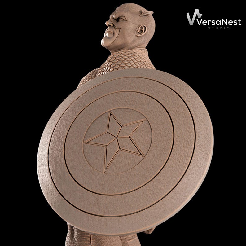 K&ouml;nnte beinhalten: Eine braune Skulptur von Captain America, der seinen Schild h&auml;lt. Der Schild ist rund mit einem Stern in der Mitte und konzentrischen Kreisen. Die Skulptur ist vor einem schwarzen Hintergrund. Das Logo von VersaNest Studio befindet sich oben rechts.