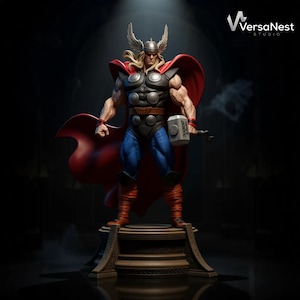 May include: A detailed statue of Thor, the Marvel Comics superhero, stands on a decorative platform. The figure is muscular, wearing a helmet with wings, a red cape, and holding a hammer. The statue is painted with vibrant colors and features the "VersaNest Studio" logo.