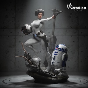 Peut inclure: Statue détaillée d'un personnage en combinaison blanche, tenant une arme et un casque. Un droïde se tient à proximité. La statue est sur une base rocheuse. Le logo VersaNest Studio est en haut à droite.