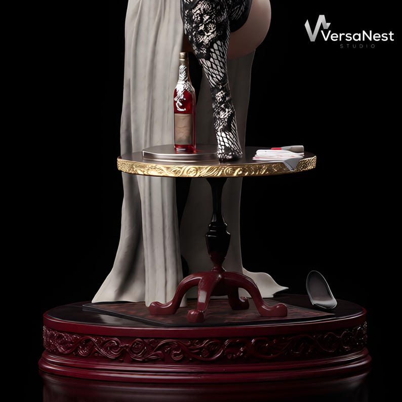May include: A sculpture of a bottle of red wine on a small, round table with a gold trim. The table is supported by a black pedestal and a red base. The sculpture includes a figure wearing a patterned stocking and a long, flowing gown. The VersaNest Studio logo is visible.