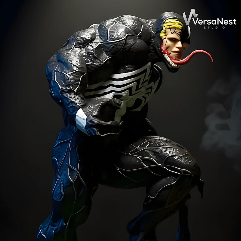 May include: A detailed sculpture of the Marvel Comics character Venom, in a dynamic pose. The figure is predominantly black with white accents and a large white spider emblem on the chest. The head features a split design with a human face and a monstrous, toothed mouth with a long red tongue.