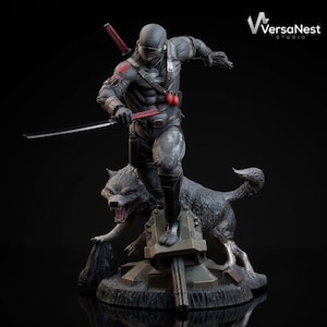 May include: A detailed statue of a ninja warrior in a black and gray suit, holding a sword, with a wolf at his feet. The figure is posed dynamically on a military-style base. The statue has red accents and is set against a dark background.