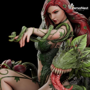May include: A detailed statue of a woman with red hair, adorned with green vines and leaves. She is posed with a dragon-like creature with a green head and a red tongue. The statue is set against a dark background.