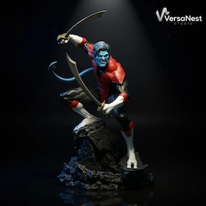 May include: A detailed figurine of a blue-skinned character in a dynamic pose, wielding two curved swords. The figure wears a red and black suit with white accents. The base is a dark, rocky structure. The VersaNest Studio logo is in the upper right corner.